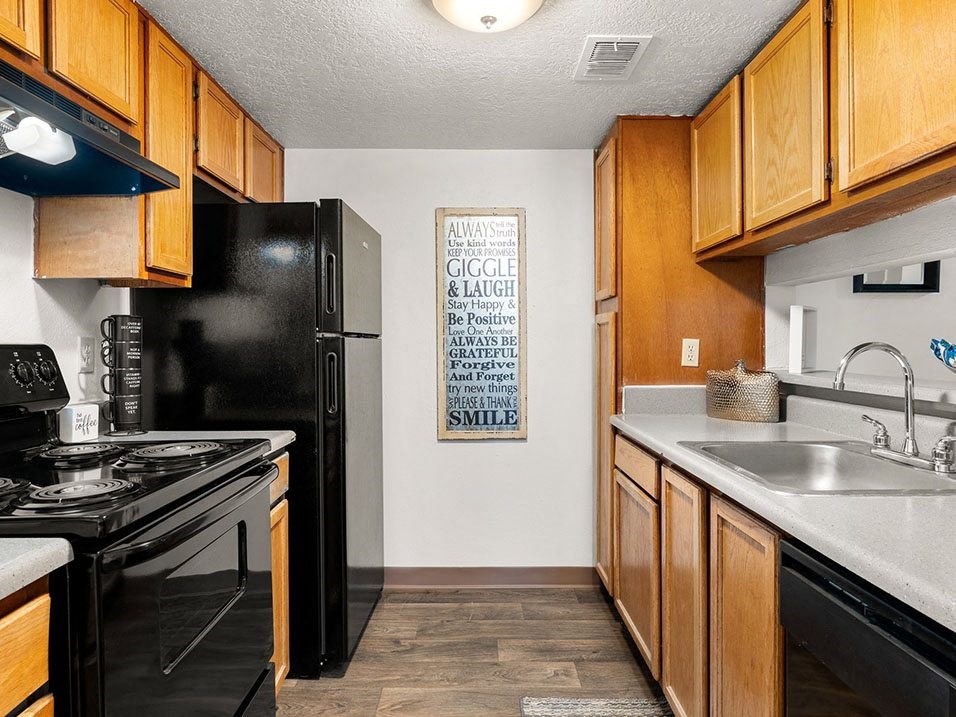 a kitchen with black appliances and wood cabinets